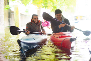 Two members canoeing on in The Hague on a sunny day smiling and having a good time.